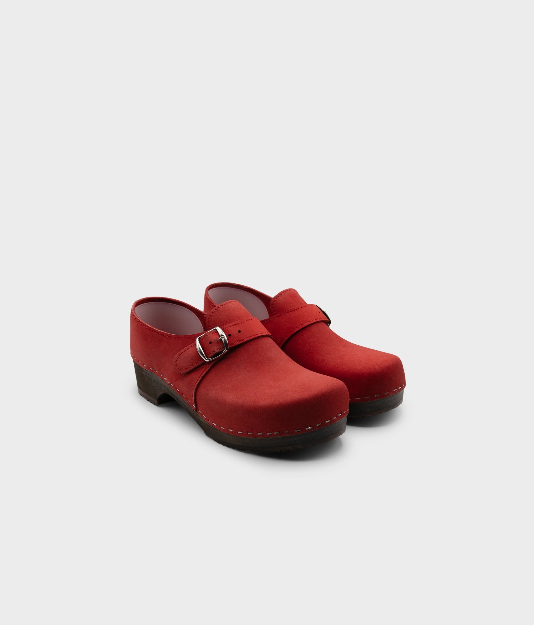 men's closed-back clogs in red nubuck leather stapled on a dark wooden base with a silver buckle
