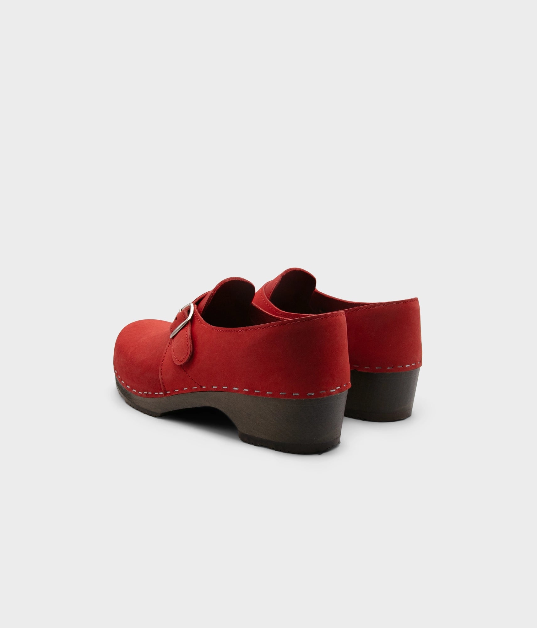 men's closed-back clogs in red nubuck leather stapled on a dark wooden base with a silver buckle