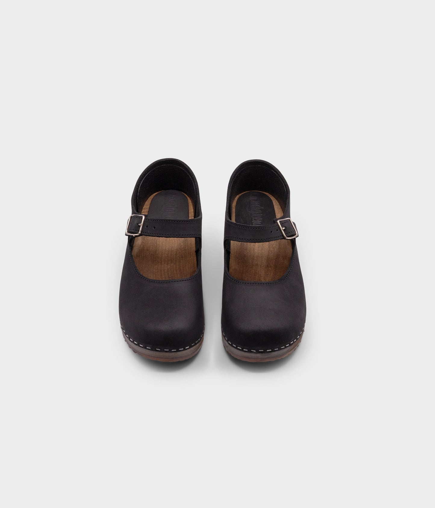 Mary Jane wooden clogs in black nubuck leather stapled on a dark wooden base
