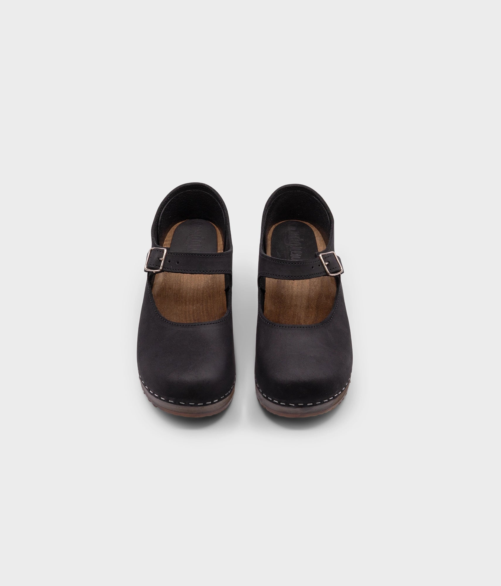 Mary Jane wooden clogs in black nubuck leather stapled on a dark wooden base