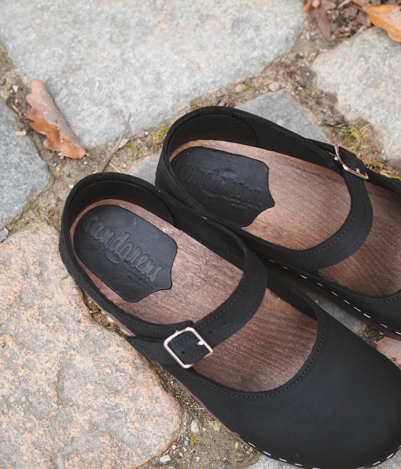 Mary Jane wooden clogs in black nubuck leather stapled on a dark wooden base