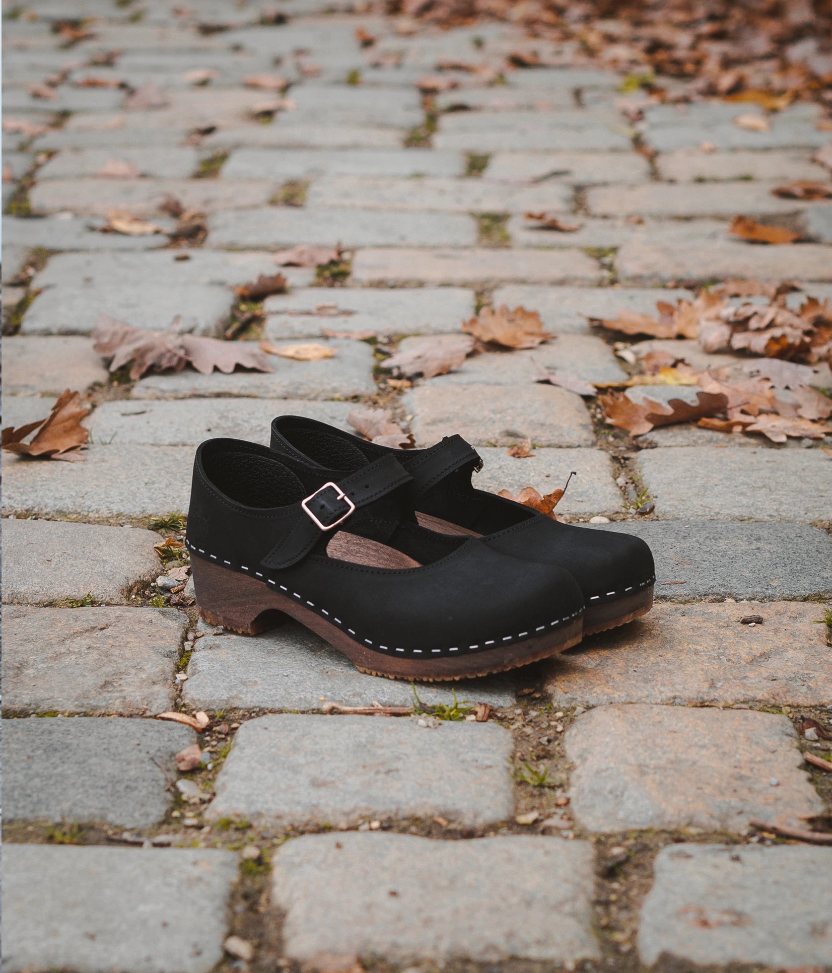 Mary Jane wooden clogs in black nubuck leather stapled on a dark wooden base