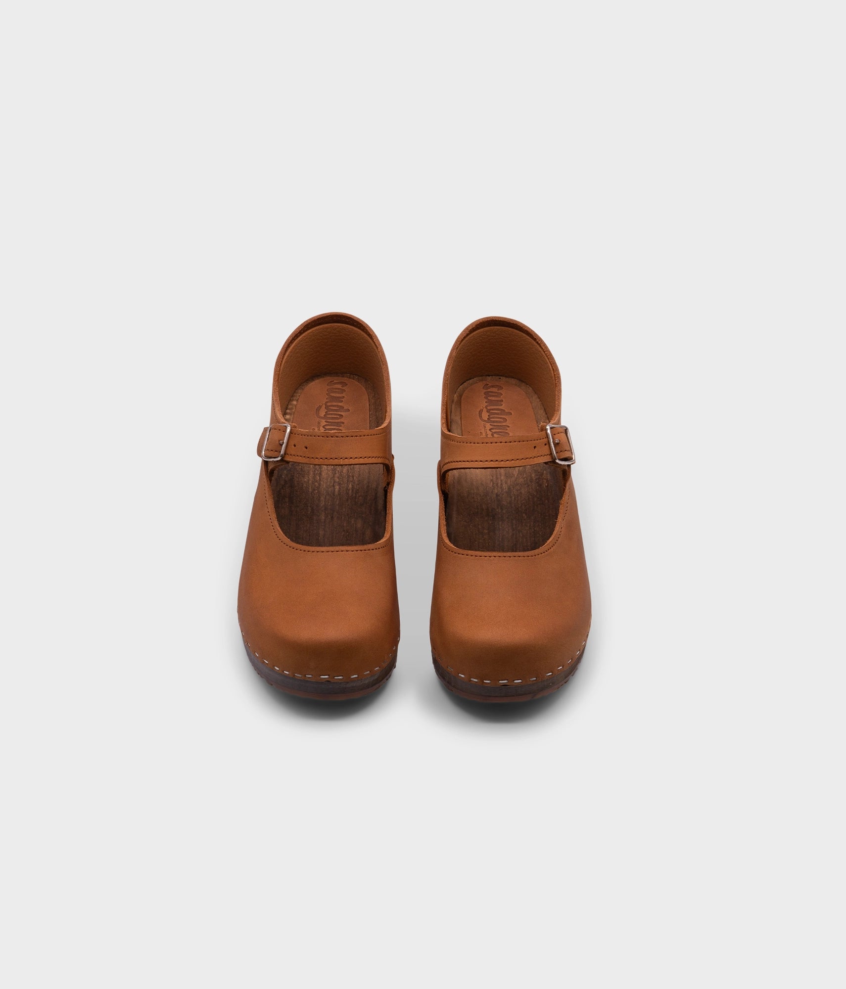 Mary Jane wooden clogs in light brown nubuck leather stapled on a dark wooden base