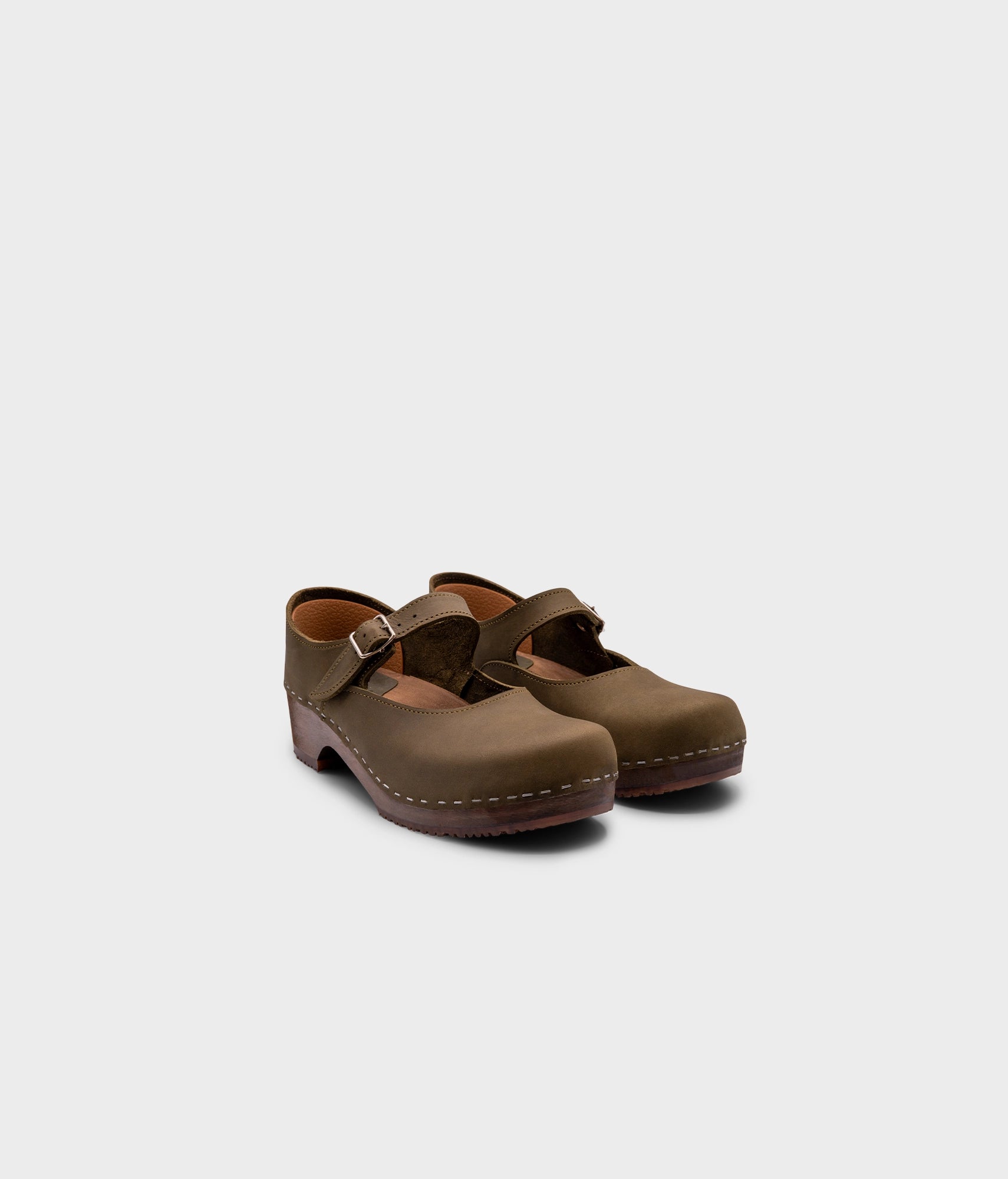 Mary Jane wooden clogs in olive green nubuck leather stapled on a dark wooden base