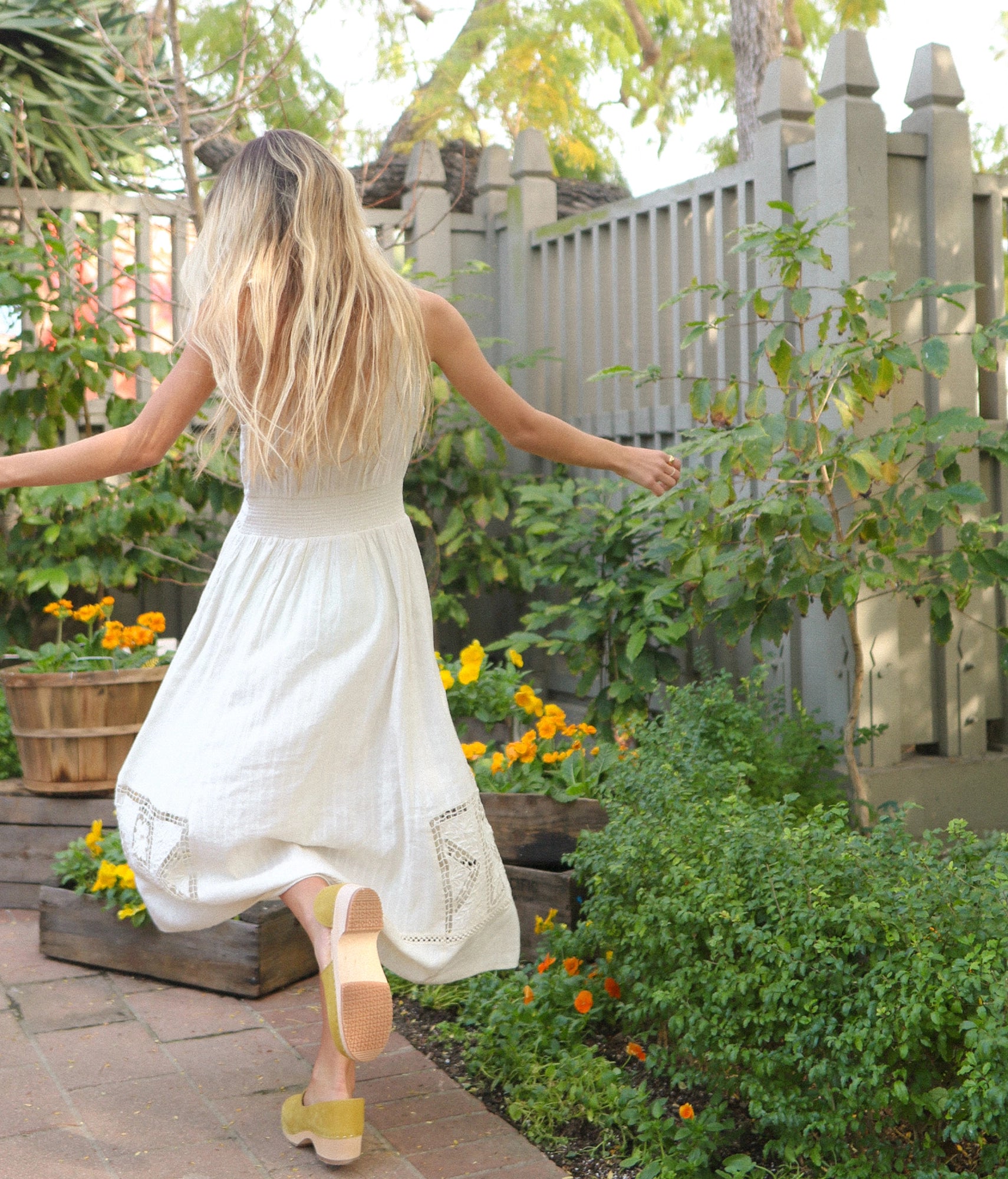 low heeled closed-back clogs in yellow nubuck leather stapled on a light wooden base