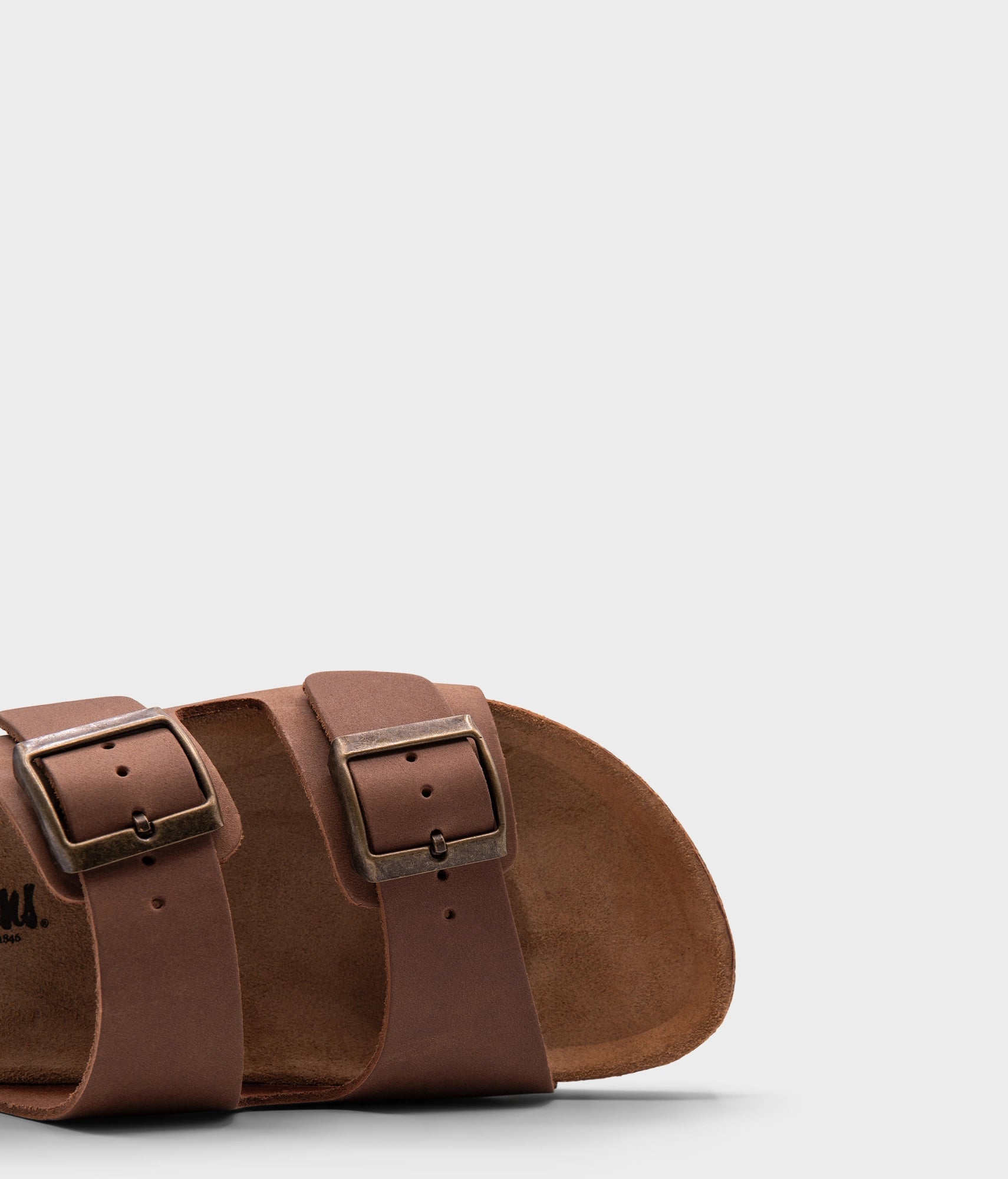 classic cork sandal with two straps in full-grain light brown nubuck leather, suede footbed and brass gold buckles