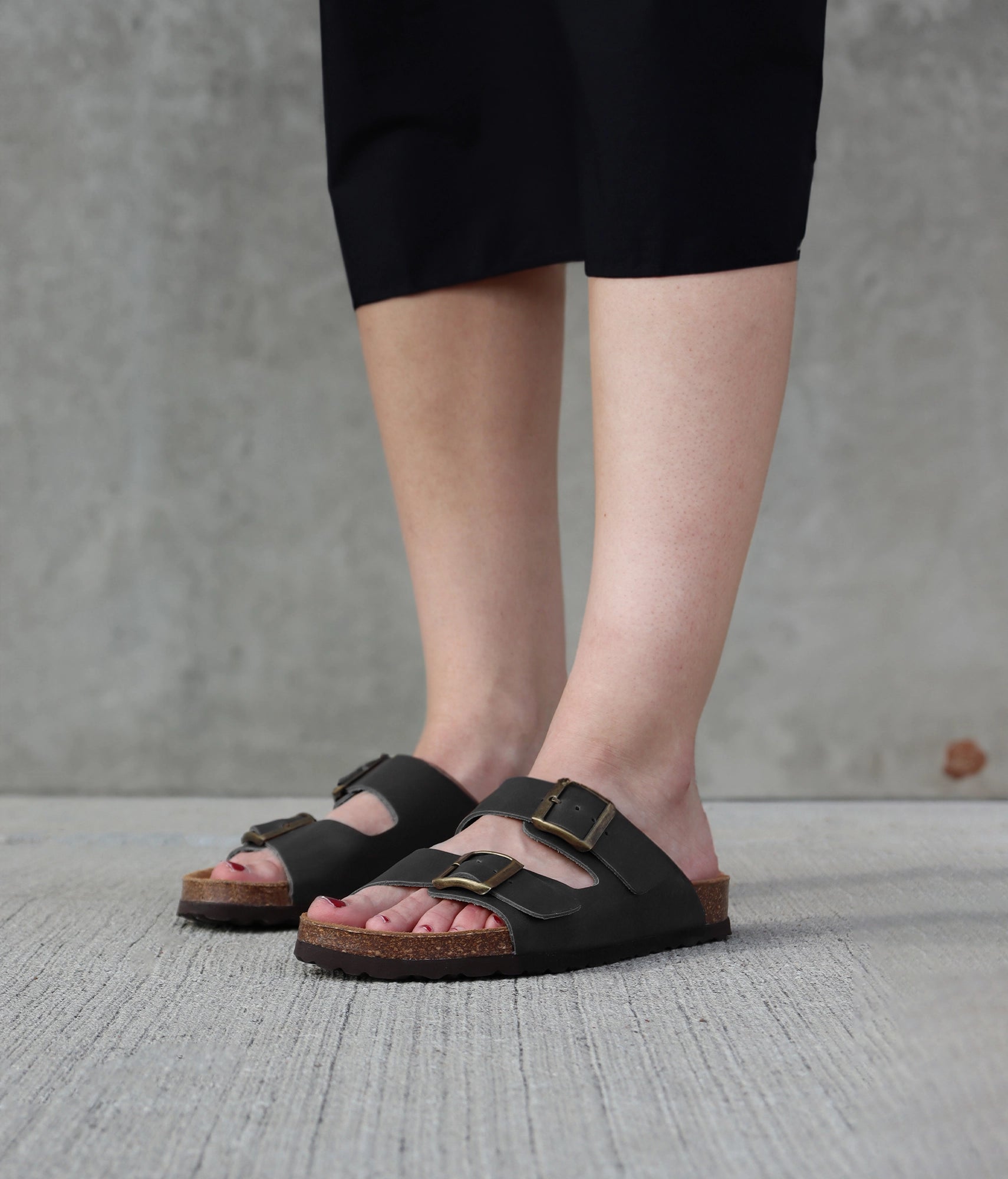 classic cork sandal with two straps in top-grain black vegetable tanden leather, suede footbed and brass gold buckles