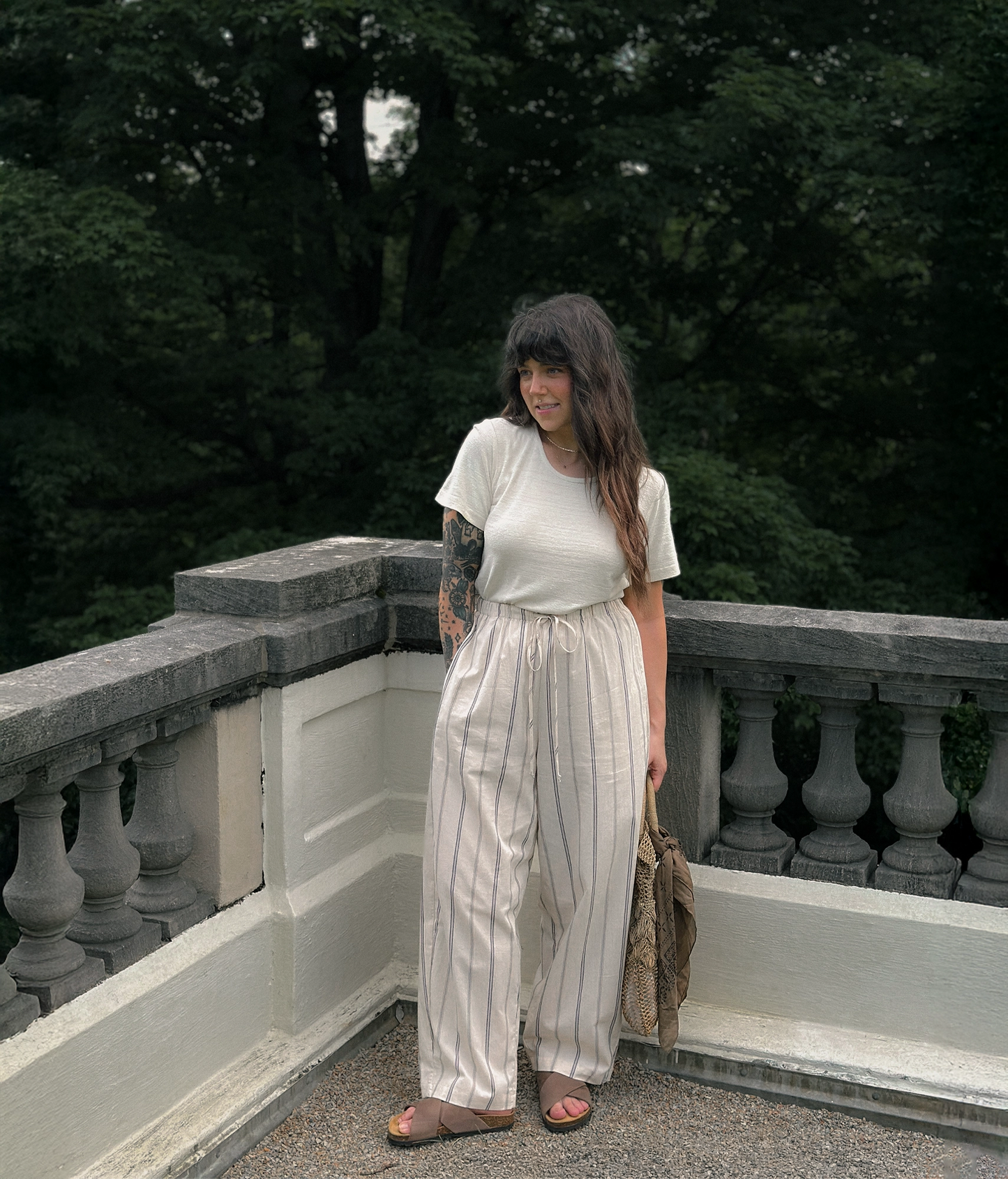 Woman wearing criss cross cork sandals in walnut brown oiled full-grain nubuck leather with a brown EVA outersole and suede footbed