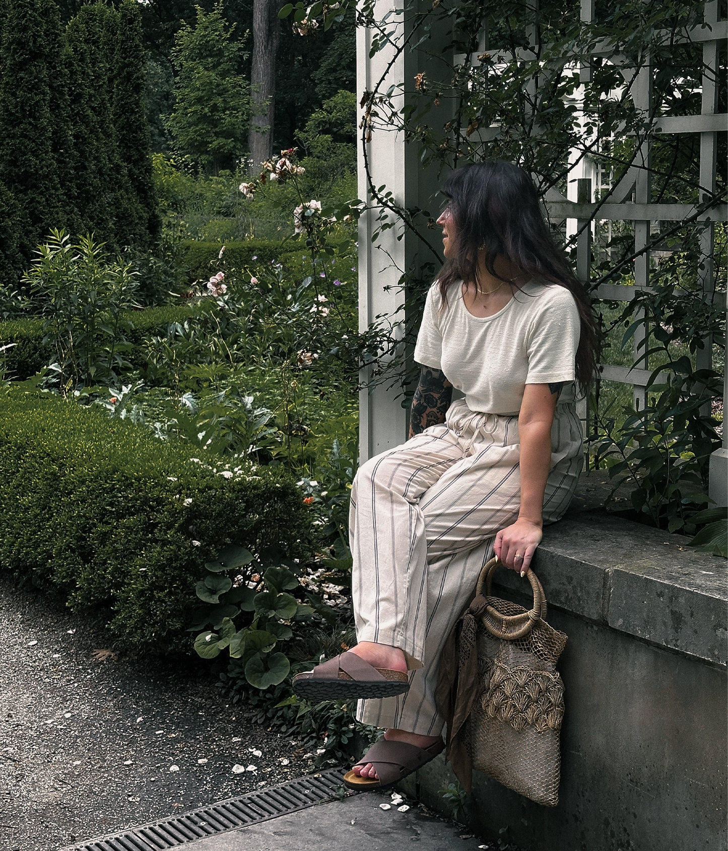 Woman wearing criss cross cork sandals in walnut brown oiled full-grain nubuck leather with a brown EVA outersole and suede footbed