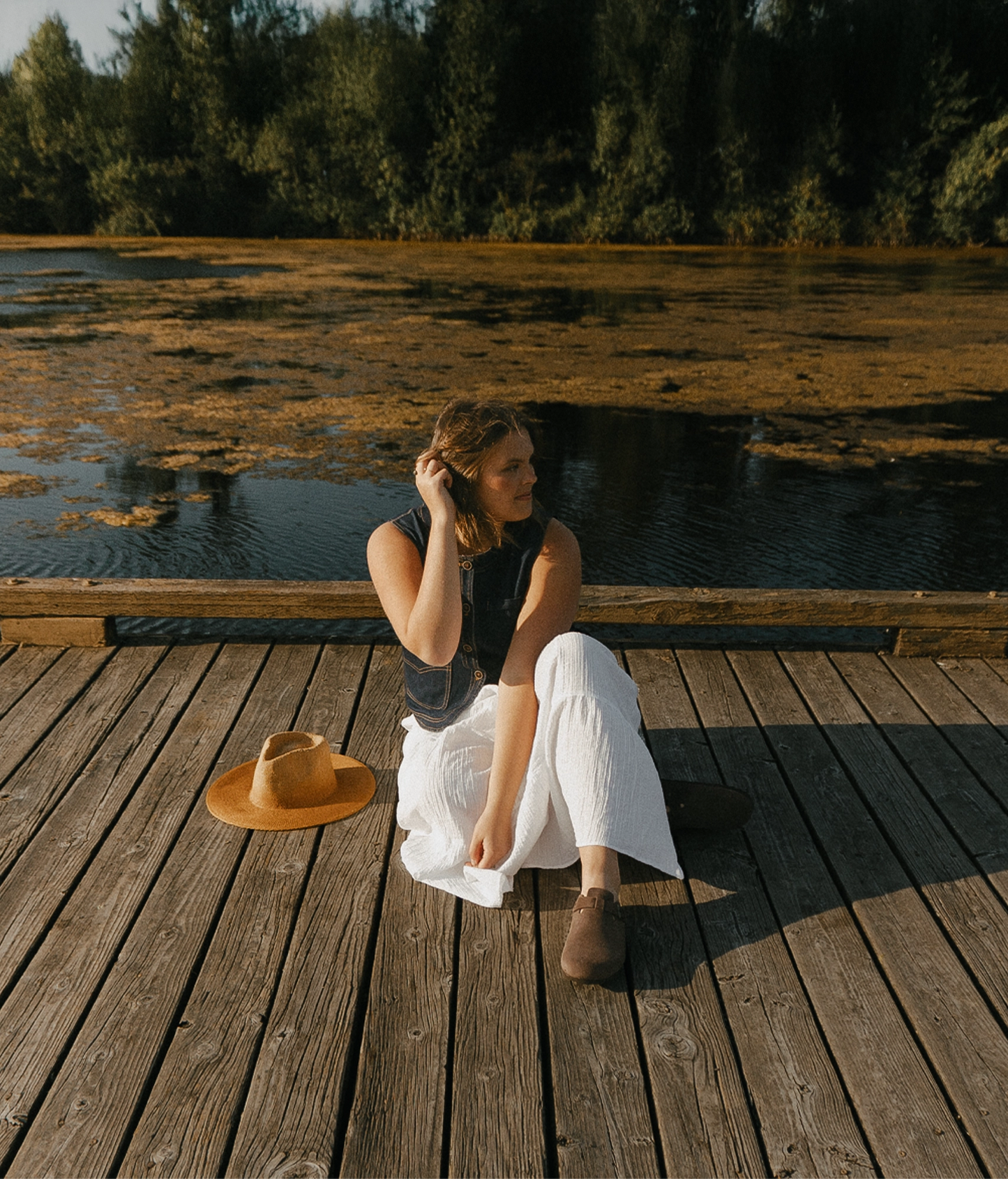 Women sitting down on a wooden surface with handmade clog mules from Sandgrens in our Walnut Brown nubuck eather
