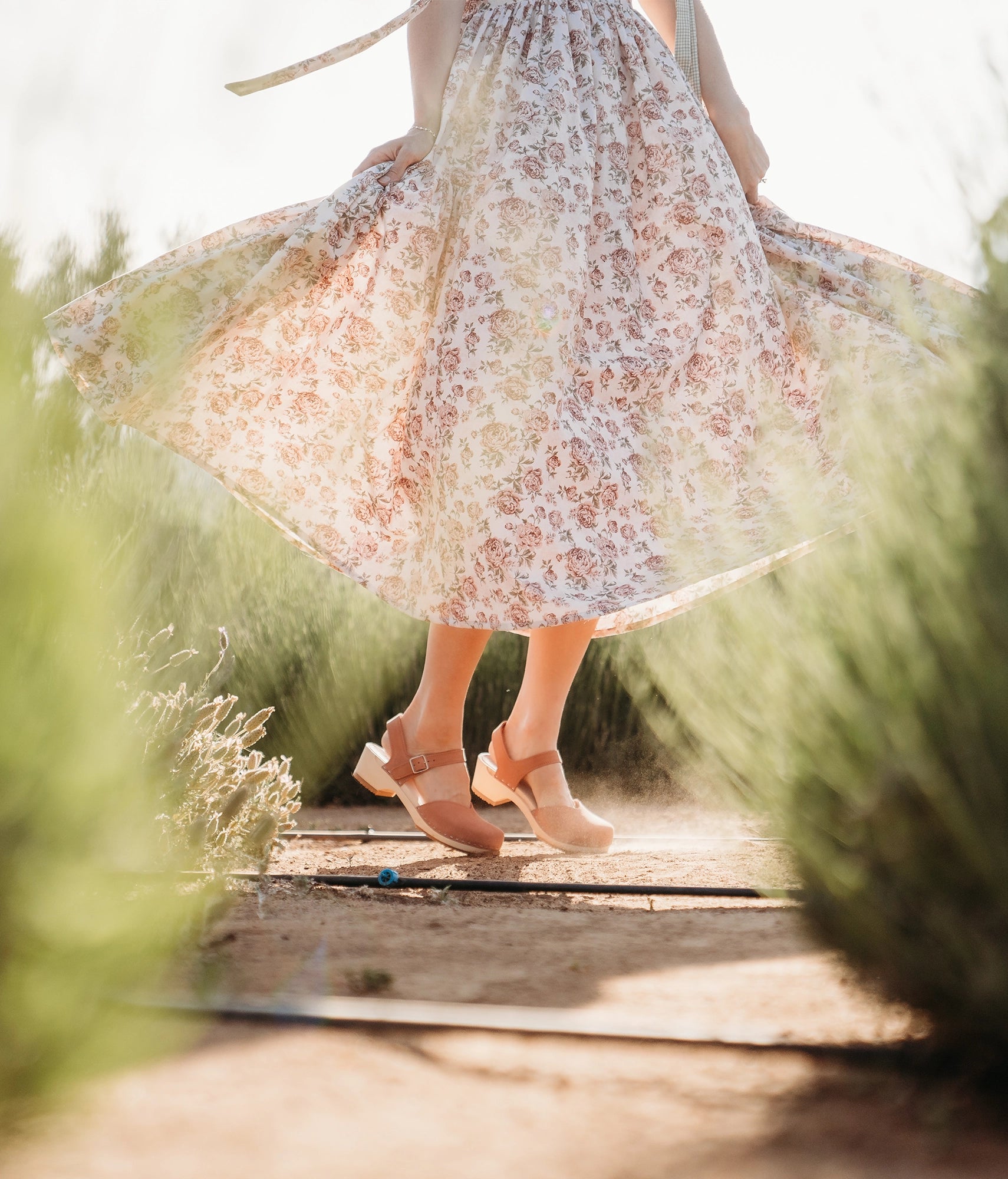 classic low heeled closed-toe sandal in blush pink nubuck leather stapled on a light wooden base