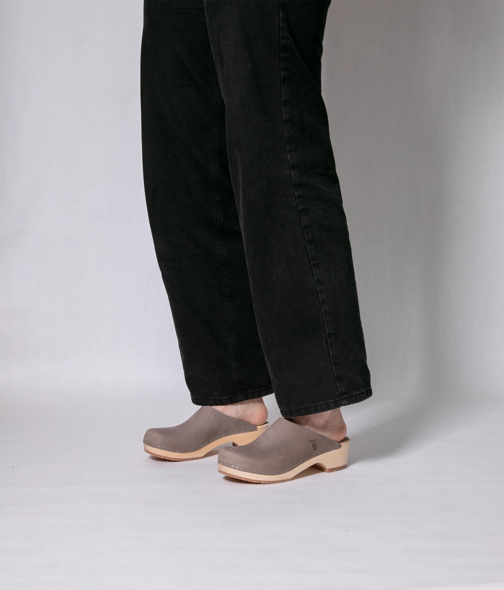 low heeled minimalistic clog mules in stone grey nubuck leather stapled on a light wooden base